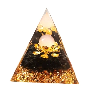 Handcrafted crystal pyramid with black gravel, lotus ornament, and golden glitter base