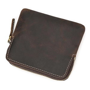 Detailed close-up of dark brown genuine leather coin purse with white stitching and metal zip