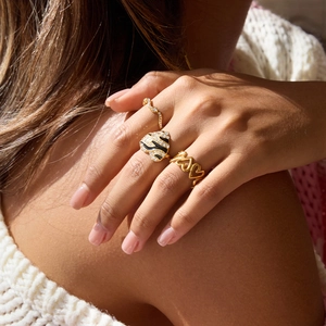 Detailed close-up of golden zebra pattern heart ring and crystal eternity bands