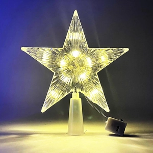 Detail of warm glow LED transparent star tree topper with battery pack and base