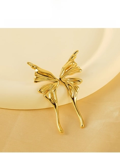 Macro shot of mirror-polished gold butterfly stud earring in titanium steel