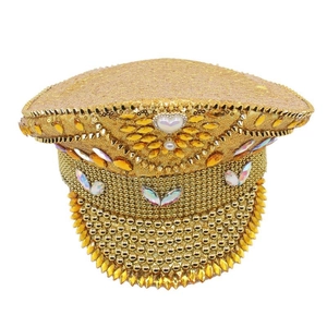 Detailed close-up of golden captain hat featuring sequins, amber rhinestones and heart gems