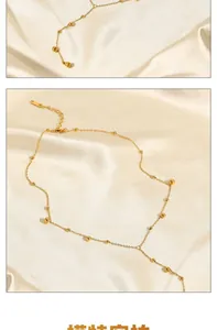 Macro detail of 18K gold plated Y-shaped necklace with bead charms on silk fabric