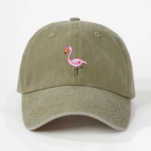 Detailed close-up of pink flamingo embroidery on washed khaki cotton baseball cap