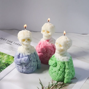 Detailed view of skull mummy candles in purple, pink, and green colors for Halloween