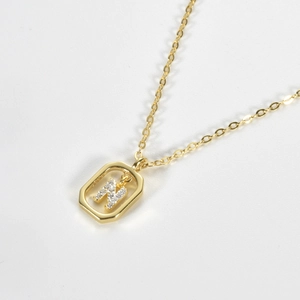 Detail of S925 silver necklace with sparkling zircon letter N pendant in gold finish