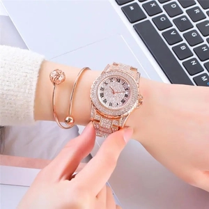 Detaillierte Nahaufnahme einer luxuriösen Strassuhr in Roségold und Armreif am Handgelenk
