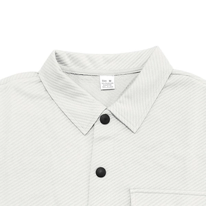 Detail of off-white twill shirt collar with black matte buttons and composition label