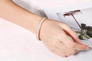 Détail d'un bracelet en acier inoxydable or rose avec pavé de cristaux au poignet
