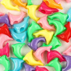 Macro shot of colorful dolphin-shaped plastic beads with center holes for DIY jewelry