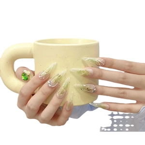 Handmade stiletto press-on nails featuring green hand-painted butterflies and 3D gold accents