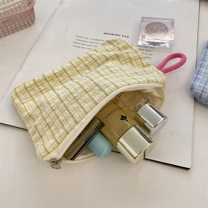 Vista dettagliata della borsa a quadri gialli con cosmetici e prodotti per la cura