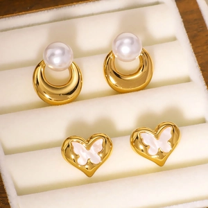 Golden hoop earrings with white pearls and heart studs with butterfly shell inlay