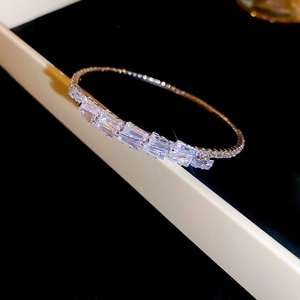 Detail view of baguette-cut zircons and pavé setting on a silver square open bangle