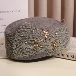 Detail of wool beret featuring mesh bow with star beadwork and pearl accents