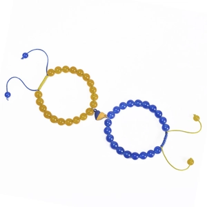 Detail of yellow and blue beaded bracelets with heart-shaped magnetic clasp closure