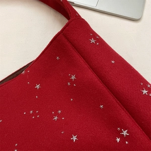 Dettaglio della borsa tote in lana rossa con motivi a stelle di paillettes argento lucido