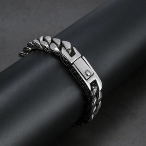 Silver alloy bracelet with intricate links and vintage totem pattern on black stand