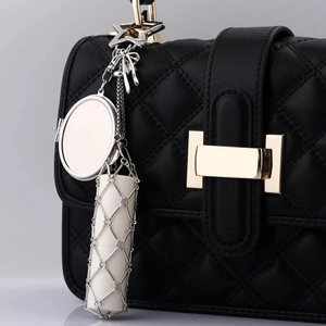 Detailed view of lipstick pouch attachment with silver mesh and luxury leather bag accessories