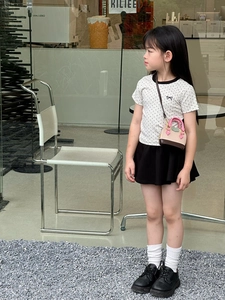 Fillette en tenue d'été avec un mini sac à bandoulière en forme de coquillage