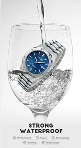 Macro view of blue dial quartz watch splashing in water to show high waterproof rating