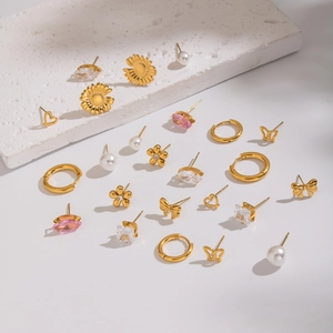 Flat lay of gold stud earrings set featuring sunflowers, butterflies, and pink zircons