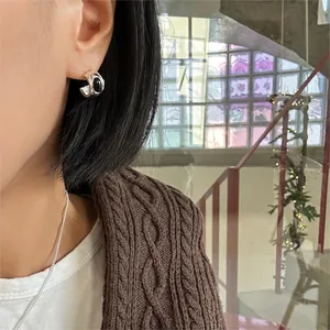 Detailed close-up of 925 sterling silver hoop earring with black oval stone and star stud