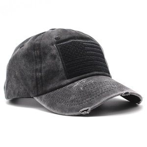 Detailed view of washed charcoal grey baseball cap with embroidered flag and tactical velcro
