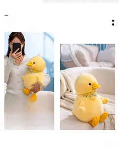 Detail showing a yellow duck plush with floral scarf held by a model for size comparison