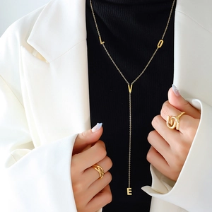 Collana LOVE dorata con frange e anelli geometrici indossata da una modella