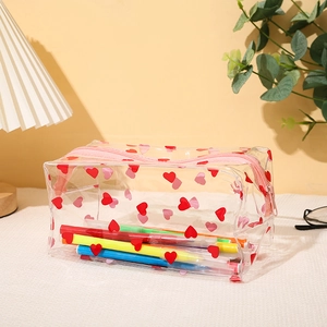 Vue détaillée de la trousse en PVC transparent avec motifs cœurs rouges et fermeture