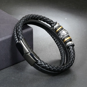 Close-up of multi-layer black braided leather bracelet with silver and gold metal beads