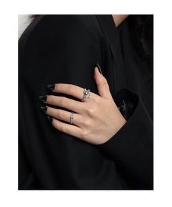 Macro shot of silver liquid metal rings with black heart gemstone on a model hand