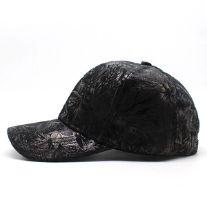 Détail d'une casquette noire avec motif de feuilles métalliques et tissage jacquard