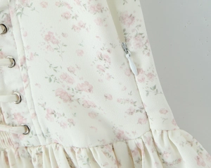 Détails de la robe florale avec fermeture éclair invisible, œillets métalliques et plis à la taille