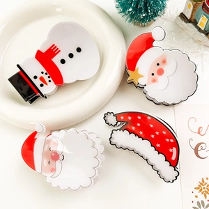 Detail view of festive Christmas hair claws featuring Santa, snowman and hat designs