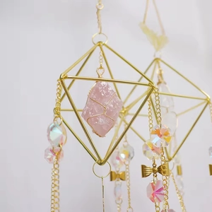 Golden geometric butterfly wind chime with raw pink crystal and iridescent pendants