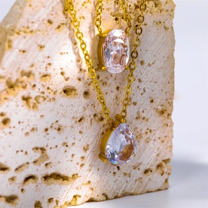Macro shot of gold double-layer necklace with oval and teardrop zircon pendants