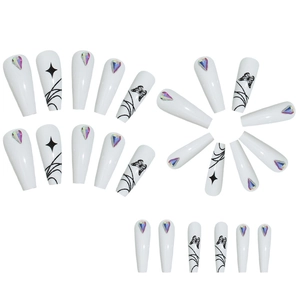 Long white press-on nails with black butterfly designs and heart-shaped rhinestones