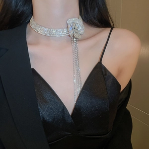 Dettaglio della collana girocollo con fiori di strass e frange luccicanti su modella