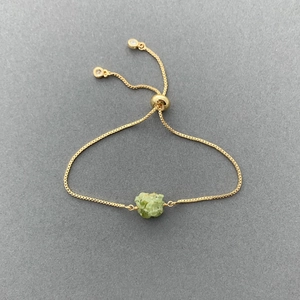 Detailed macro view of 14K gold-plated adjustable box chain with natural green gemstone