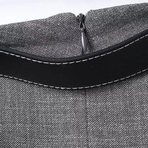 Detail of hidden zipper and black waist belt with white stitching on grey textured fabric