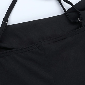 Détail d'une robe noire présentant des bretelles réglables et des finitions de couture