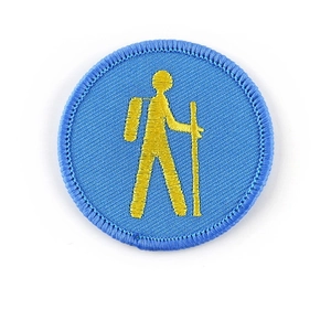 Circular hiking theme embroidery patch with blue background and yellow hiker silhouette