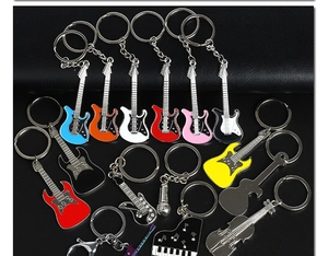 Detailed flat lay of colorful enamel musical instrument metal guitar and violin keychains