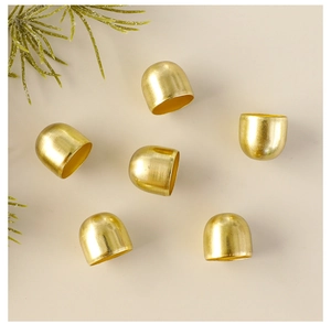 Macro shot of six golden metal bell caps with brushed texture on warm beige background