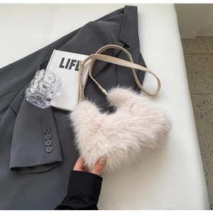 Close-up of cream faux fur bag with adjustable beige leather strap and fluffy texture