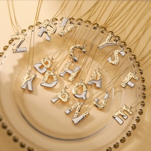 Two-tone alphabet pendant necklaces with lava texture on gold chain display