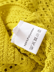 Macro shot of yellow halter top fabric showing 100% polyester knit texture and care label