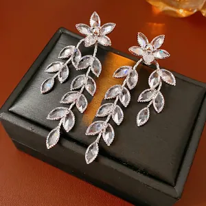 Elegant silver tassel earrings with flower and leaf-shaped zircons on jewelry box